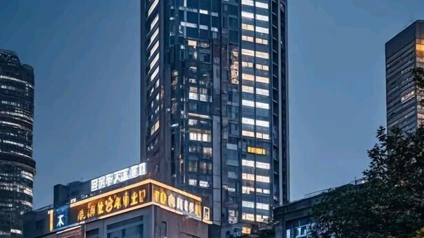 Un edificio de gran altura con varios pisos, ventanas amplias y un letrero con caracteres chinos.