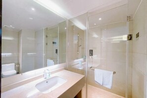 A modern bathroom with a large mirror, a sink, and a glass-enclosed shower area. - City Comfort Inn (Zhuji Xishi Theater Yongli Plaza) (Zhuji)
