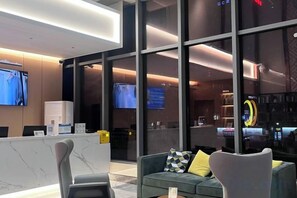 A modern hotel lobby with a reception desk, seating area, and large windows. - City Comfort Inn (Zhuji Xishi Theater Yongli Plaza) (Zhuji)