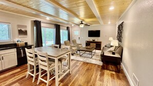 A spacious living area with a dining table, chairs, a sofa, and a TV. - Mountainside Luxury Unit 3—LOCATION! LOCATION! (Mena)