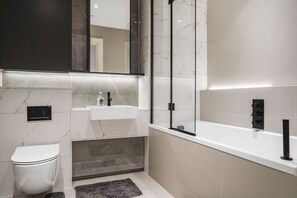 Een bad/douchecombinatie, een haardroger, handdoeken