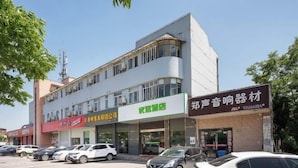 A multi-story building with various businesses on the ground floor, including a Yamaha store. - Preferred Hotel (Shanghai Sheshan) (Shanghai)
