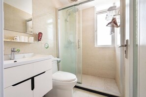 A modern bathroom with a glass-enclosed shower, a toilet, and a sink with a mirror above. - Preferred Hotel (Shanghai Sheshan) (Shanghai)
