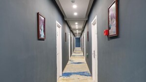 A hallway with grey walls, framed pictures, and a patterned carpet. - Preferred Hotel (Shanghai Sheshan) (Shanghai)