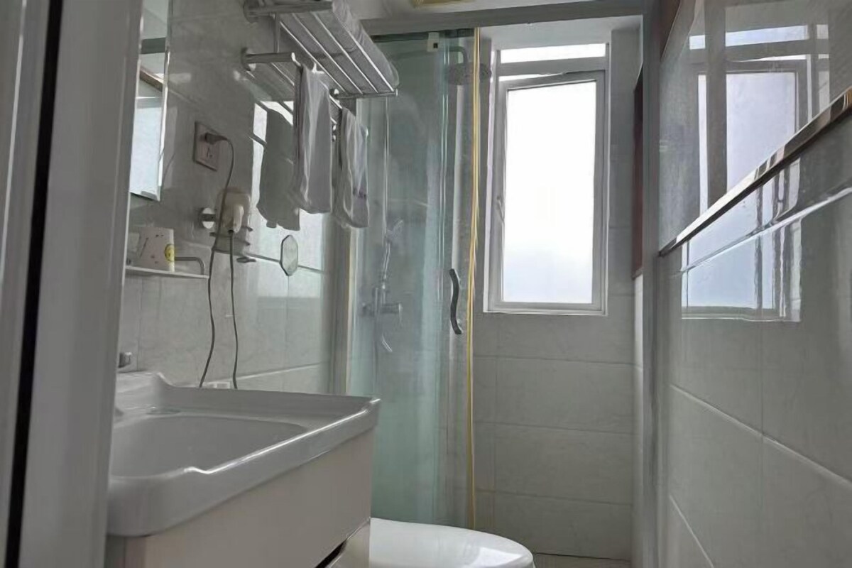 A bathroom with a shower, toilet, and sink.