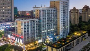 A multi-story building with a glass facade, surrounded by other high-rise buildings. - YFT Hotel (Haichang South Road Yintaicheng Branch) (Haining)