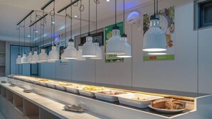 A buffet setup with multiple food stations and hanging pendant lights. - YFT Hotel (Haichang South Road Yintaicheng Branch) (Haining)