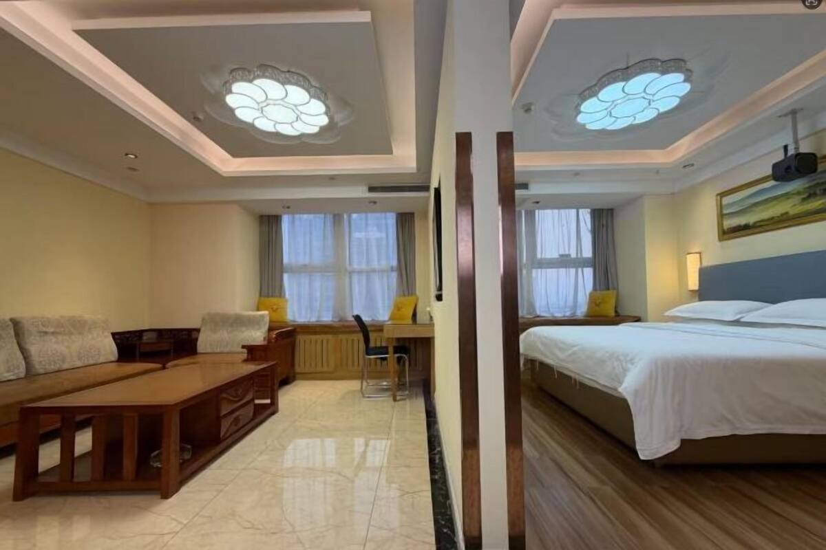 Una habitación de hotel con cama, sofá, escritorio y silla.