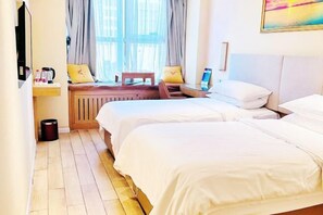 A hotel room with two beds, a wooden floor, a window with curtains, a small table with a laptop, and a painting on the wall. - Vienna 3 Best Hotel (inan Changqing University Town) (Jinan)