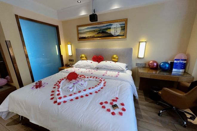 Ein Hotelzimmer mit einem Bett, einem Schreibtisch, einem Sessel und einem Bild an der Wand.