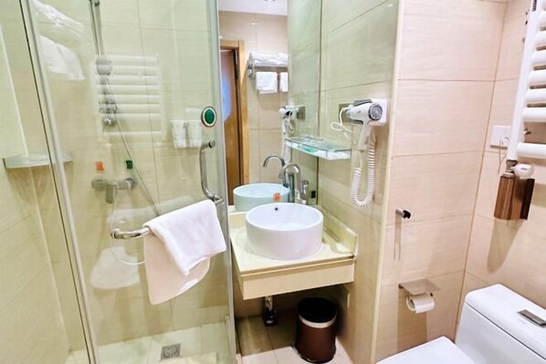 A bathroom with a glass shower enclosure, a white sink, a mirror, a towel rack, a toilet, and a trash bin. - Vienna 3 Best Hotel (inan Changqing University Town) (Jinan)