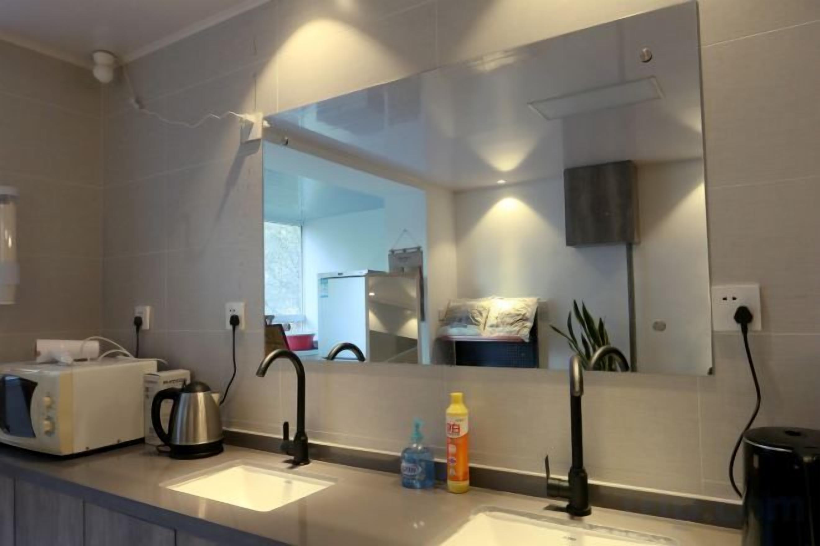 A modern bathroom with two sinks, a large mirror, and a towel rack.