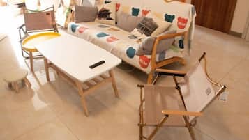 A room with a sofa, a small table, and a chair.