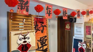 Een kamer met een traditionele Chinese deur, rode decoraties en een bord met Chinese karakters.