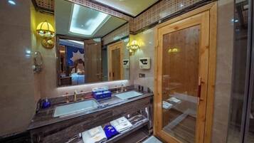 A modern bathroom with a large mirror, dual sinks, and a wooden door.