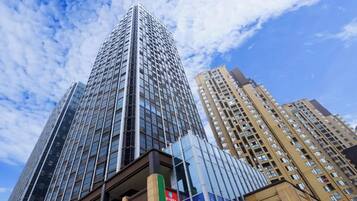 Un edificio de gran altura con fachada de vidrio moderna y una señalización visible.