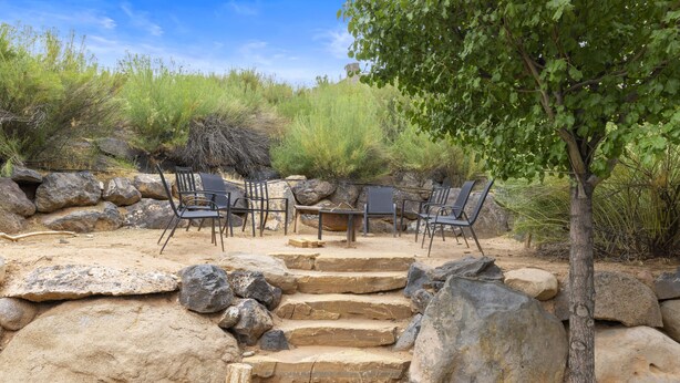 A patio with outdoor furniture, a stone staircase, and surrounding vegetation. - Hot Tub Game Room. Sleeps 17. You Tube TV. 20 minutes to Zions Natl Park (La Verkin)