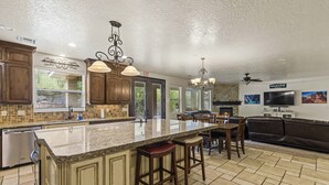 A spacious kitchen with granite countertops, wooden cabinets, and a central island with bar stools. - Hot Tub Game Room. Sleeps 17. You Tube TV. 20 minutes to Zions Natl Park (La Verkin)
