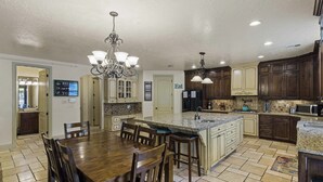 A spacious kitchen with a large island, wooden cabinetry, and a chandelier. - Hot Tub Game Room. Sleeps 17. You Tube TV. 20 minutes to Zions Natl Park (La Verkin)