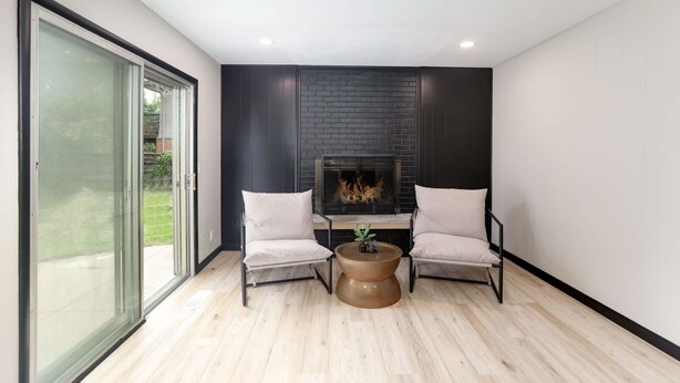 A modern living room with a fireplace, two armchairs, and a coffee table. - Amazing East Side 3BR 2BA Wifi SMRT TV (Wichita)