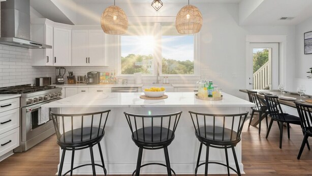 A modern kitchen with white cabinets, a central island, black bar stools, and a view of the outdoors. - Last-Minute! Soundfront, Pool, Hot Tub, Elevator, Renowned Currituck Club Access (Corolla)
