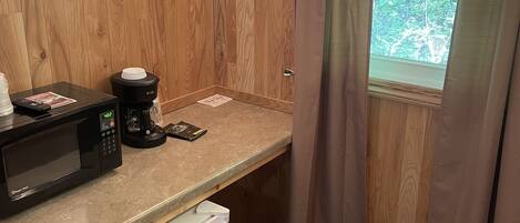 A compact kitchenette with a microwave, coffee maker, and mini-fridge.