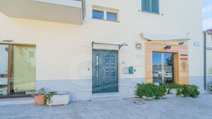 Un bâtiment avec une porte bleue, un petit auvent et une enseigne indiquant les services proposés, tels qu’un restaurant, un bar à vin et une sélection de bières artisanales.