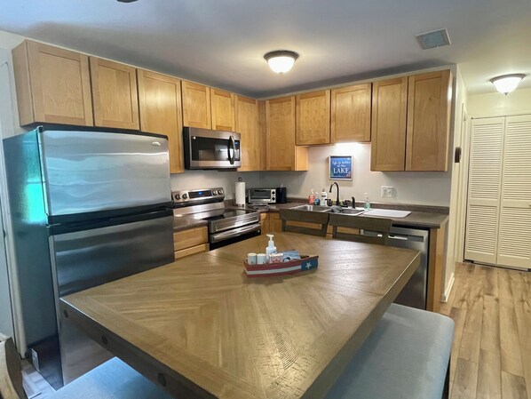 A modern kitchen with wooden cabinets, stainless steel appliances, and a central island.