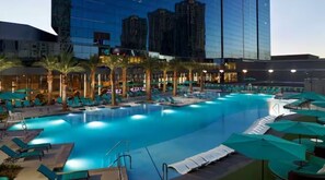 Relax by the pool surrounded by palm trees and lounge under the shade of umbrellas.