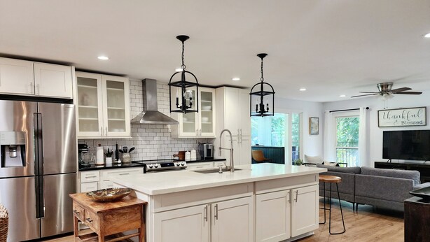 A modern kitchen with white cabinetry, stainless steel appliances, and a central island. - Unique, private and central (Mililani)