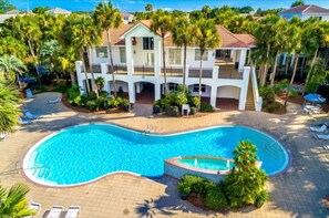 Relax by the resort's large pool surrounded by lush palm trees and lounge chairs.