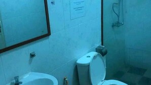 A bathroom with a sink, toilet, and shower. - Sea Inn Guesthouse (Sihanoukville)