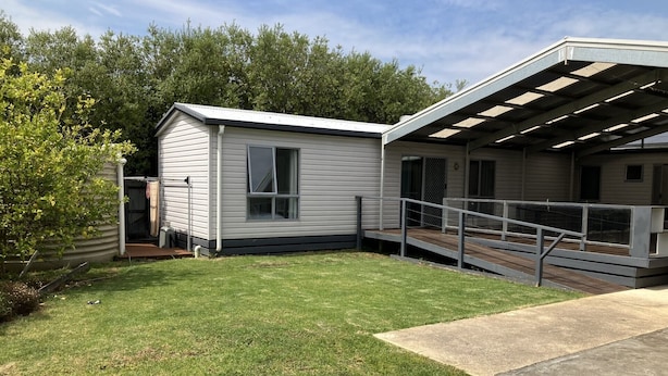 A single-story mobile home with a covered patio area and a small front yard. - Central convenience for groups and families - Portarlington entertainer! (Portarlington)