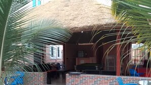 A building with a thatched roof, a pool table, and blue plastic chairs. - 6A Resort and Hotels Owerri (Owerri)