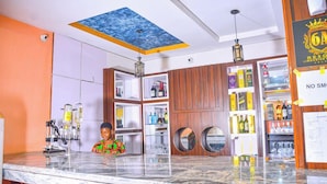 A bar area with a marble countertop, wooden cabinets, and a ceiling with a blue artwork. - 6A Resort and Hotels Owerri (Owerri)