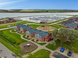 Un port de plaisance avec des bateaux, une aire de jeux et des bâtiments aux toits rouges.