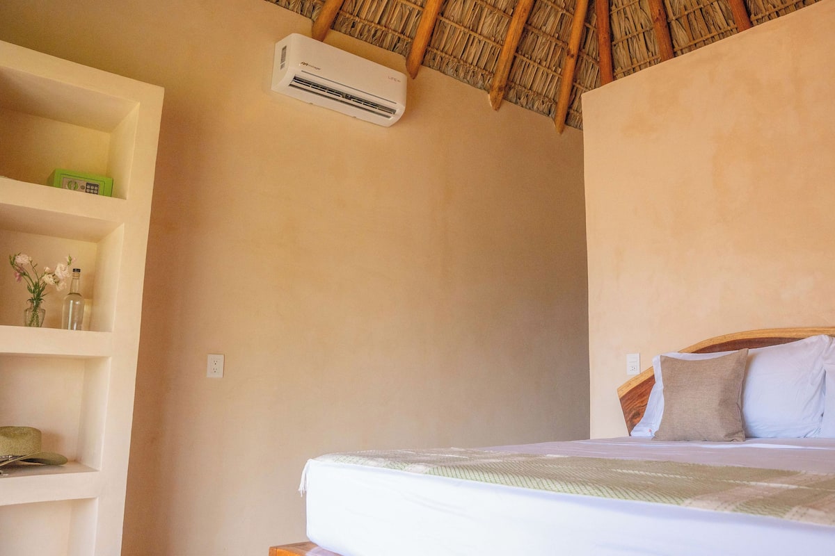 Un dormitorio con cama, repisas con objetos decorativos y un ventilador de techo.