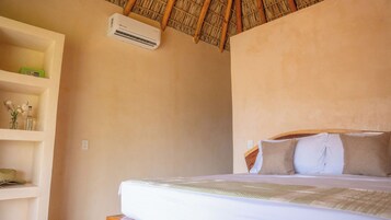 Un dormitorio con cama, repisas con objetos decorativos y un ventilador de techo.