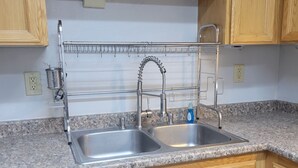 A kitchen with wooden cabinets, a double sink, and a stainless steel faucet.