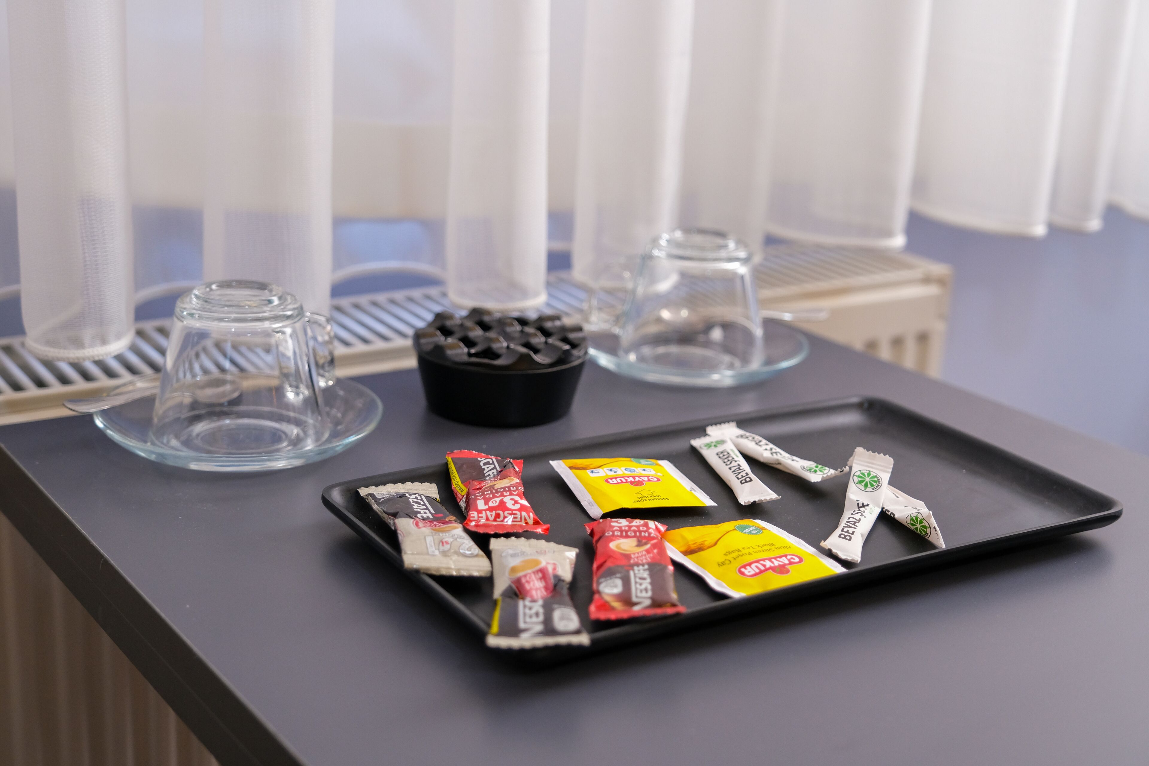 A tray with assorted snacks on a table in a hotel room.