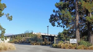 A road leading to a building with a sign that reads 'ÖPUKE.' - Opuke Crash Pad Methven - with mountain views. (Methven)
