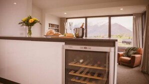 A kitchen with a wine cooler, a dining area with a view, and a sofa.