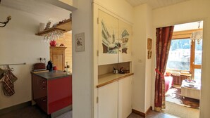Eine gemütliche Küche mit Holzausstattung, einer roten Arbeitsplatte und einem Fenster mit Blick ins Freie.