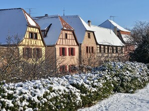 Eine Reihe traditioneller Fachwerkhäuser mit schneebedeckten Dächern und blauem Himmel.