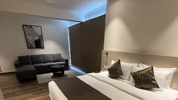 Un dormitorio moderno con una cama grande, un sofá y una pequeña mesa.