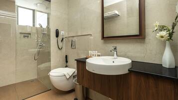 Un baño moderno con inodoro, lavamanos y ducha.