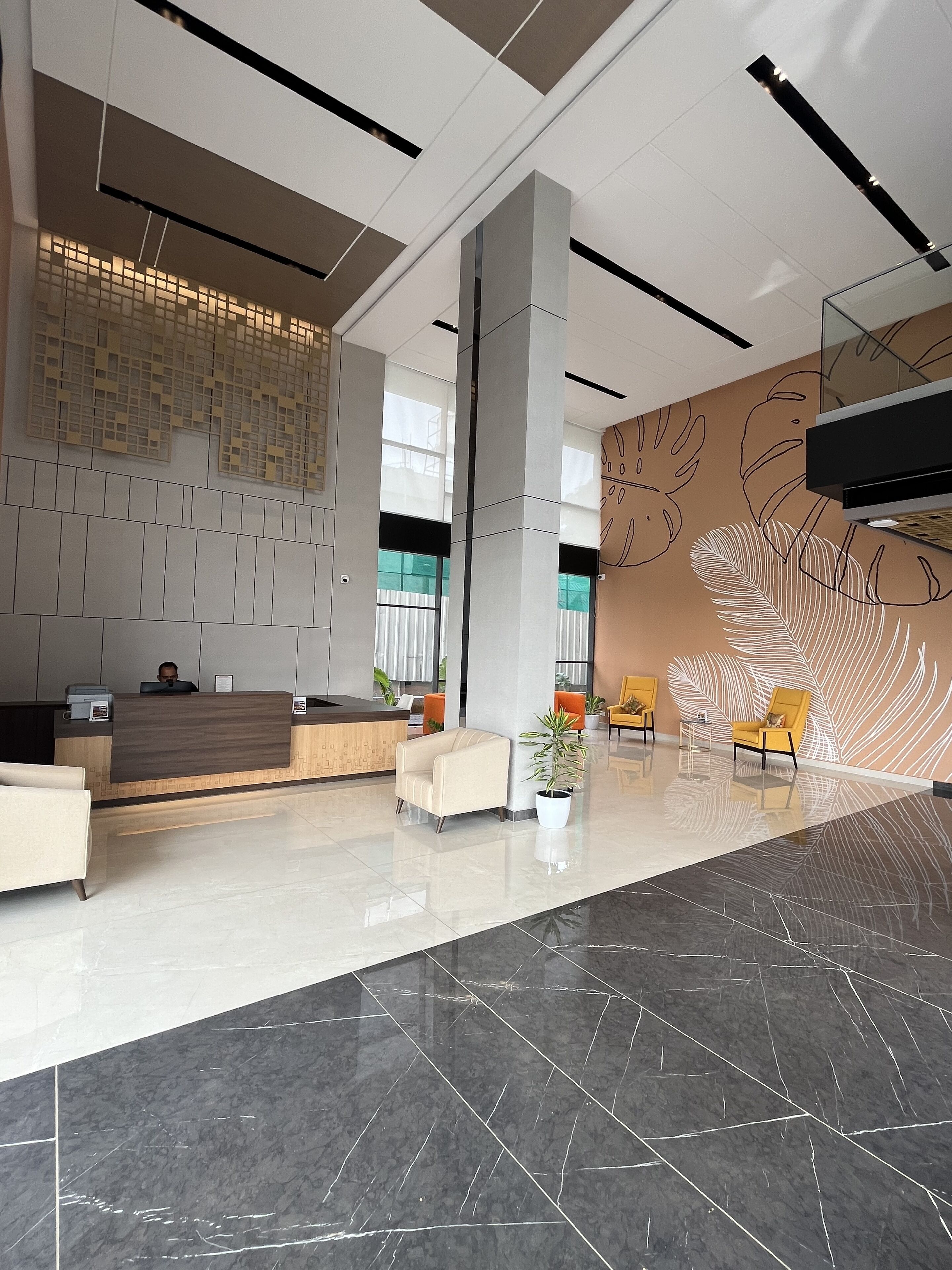 A modern reception area with a reception desk, seating, and a decorative wall.