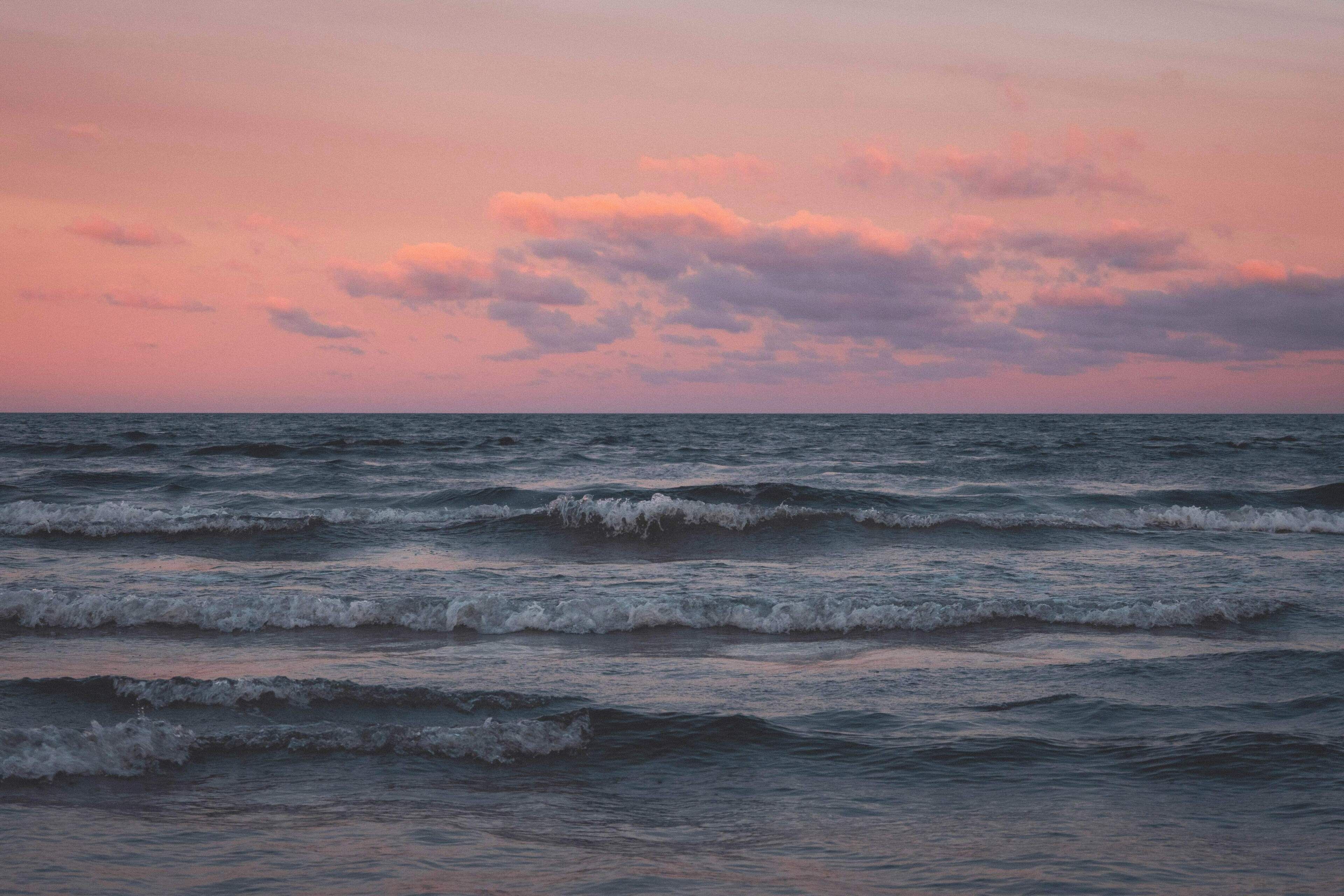 A view of the ocean with waves and a pinkish sky.