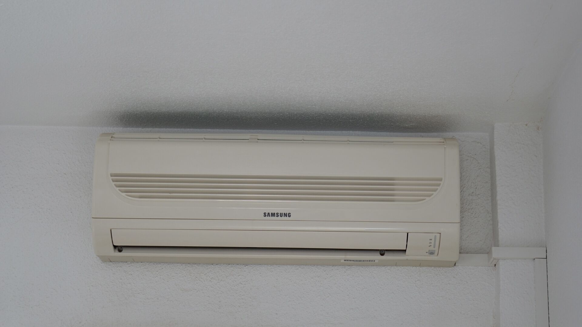 A Samsung air conditioner mounted on a white wall.