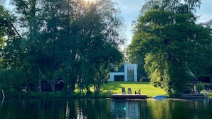 A modern house by a lake with a dock and chairs. - Rethorn Haus am See (Ganderkesee)
